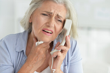 Portrait of upset senior woman calling doctor