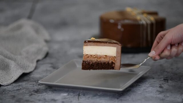 Piece of chocolate caramel peanut mousse cake, snickers on a plate.