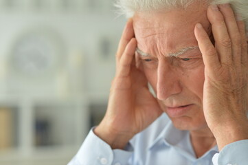 Portrait of sad sick senior man with  headache