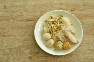 dry thin rice noodles topping slice boiled pork and ball on plate