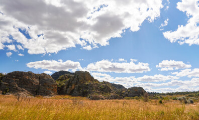 Low grass growing on African savanna, small rocky mountains in background - typical scenery at Isalo national Park, Madagascar