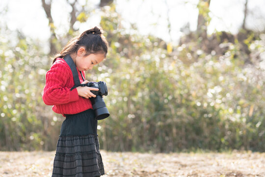 一眼レフカメラで写真を撮影する少女