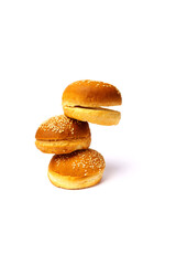 Three hamburger buns with sesame seeds isolated on white background.