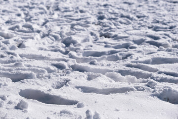 Fototapeta na wymiar Lots of footprints crisscrossed in the white snow 