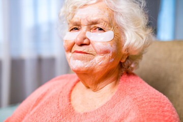 portrait of smiling senior woman with hydrogel under-eye patches