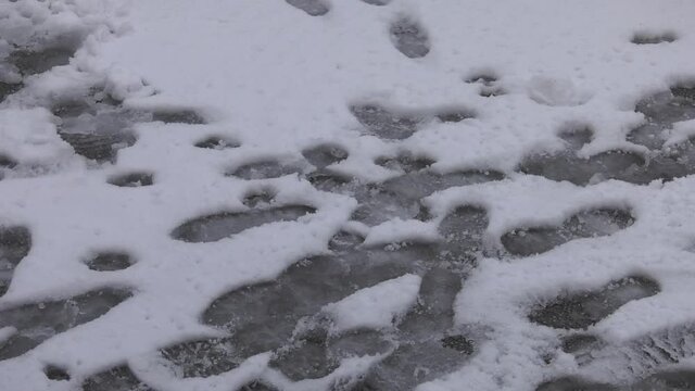 impronte di persone sulla neve fresca appena caduta in strada