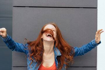 Laughing carefree young redhead woman - obrazy, fototapety, plakaty