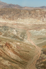 Dry riverbed leading to red rock mountains.
