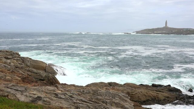 
La Torre de H&eacute;rcules de La Coru&ntilde;a desde el otro extremo de la bah&iacute;a y mar vivo