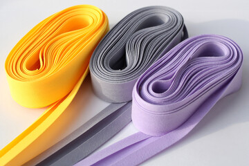 Colorful fold bias tape on white background. Coil with bias binding.Various colors.