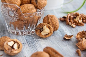Walnuts on a painted background. Crystal bowl with nuts. Useful products.