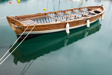 Fototapeta na wymiar Old wooden boat like from ancient Greece anchored in Floisvos Port