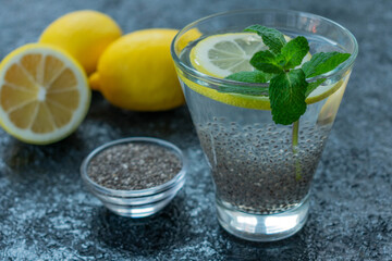 Healthy slimming drink with chia seeds and lemon on a black background.