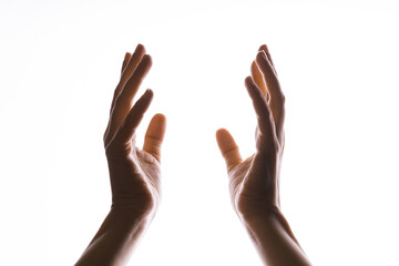 Hands make magic, or pray that the light falls from above on hand. Radiance between the palms. Gestures, isolated on white, contour lighting, contrast.