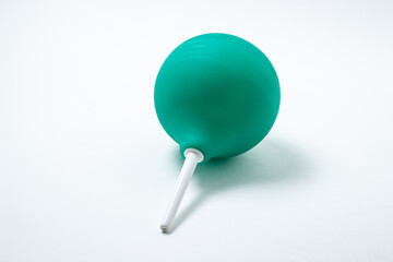 Green enema on a white background. Constipation treatment. Home treatment