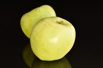 Two natural green apples by Renet Simirenko , close-up, isolated on black.