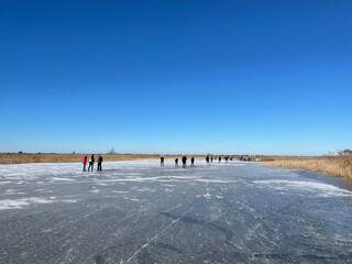People ice skating on a frozen lake around Sneek