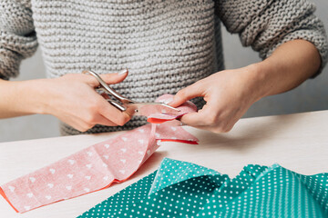 The girl cuts a shape in the form of a heart from the fabric.