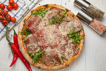 Pizza with prosciutto, arugula, tomatoes and parmesan

