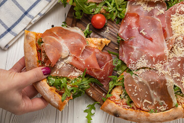 Pizza with prosciutto, arugula, tomatoes and parmesan
