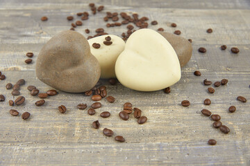 Fototapeta na wymiar Fragrant coffee natural handmade soap in the shape of a heart and coffee beans on a wooden countertop.