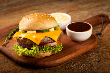 Tasty hamburger with sauces on dark background.
