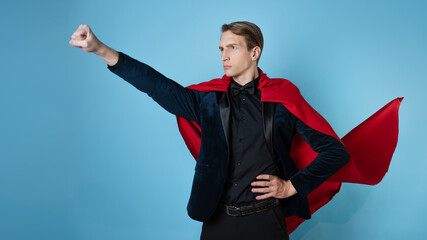 The superhero hurries forward. A young man in a suit with a red cape, superman. The concept of a...