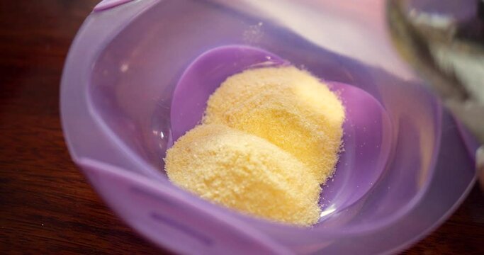 mother prepares baby porridge at home. slow motion