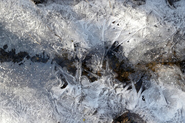 Eiskristalle wachsen von den Ufern über einen kleinen Bach