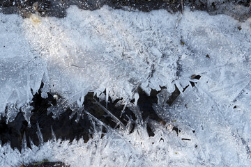 Eiskristalle wachsen von den Ufern über einen kleinen Bach
