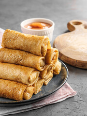 Thin crepe pancakes stuffed lie in a pyramid on the table in a rustic style. A traditional dish for the carnival.