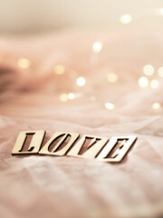 Miłość - napis z drewnianych klocków, błyszczące tło 