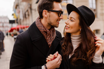 Outdoor fashionable stylish couple in love embarrassing and looking on each.