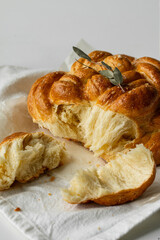 Freshly baked homemade braided brioche on white background.