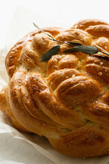 Freshly baked homemade braided brioche on white background.