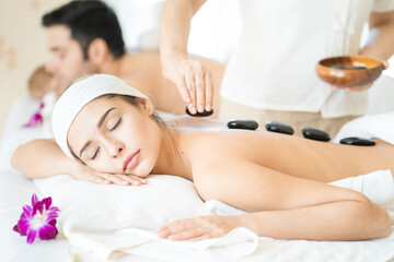 young woman lying on massage table and receiving therapeutic spa procedure.