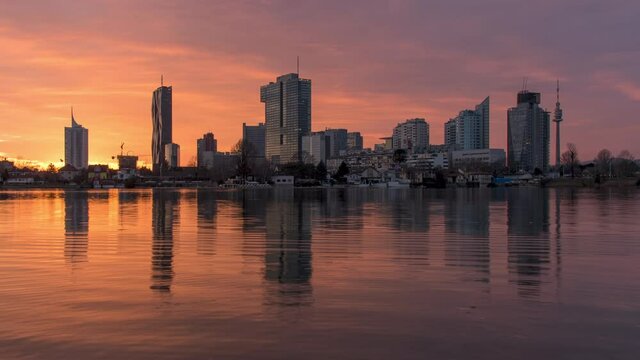 Zeitraffer Wien Skyline Tag zu Nacht. An der alten Donau mit sch&ouml;nem Farbverlauf und Spiegelung im Wasser