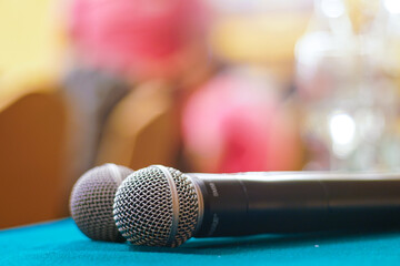 Microphone over the abstract blurred conference hall room