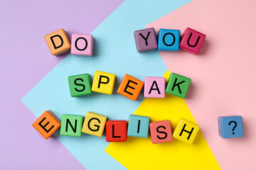 Cubes with question Do You Speak English on color background, flat lay