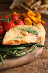 Delicious cooked chicken and vegetables on wooden table, closeup. Healthy meals from air fryer