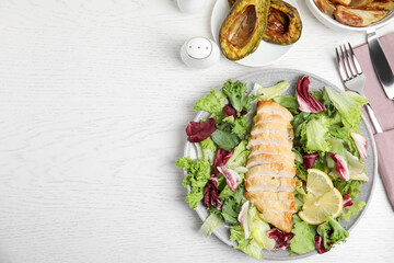 Tasty cooked chicken fillet with fresh salad  and space for text on white wooden table, flat lay. Healthy meals from air fryer