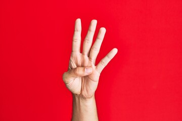 Arm of caucasian white young man over red isolated background counting number 4 showing four fingers