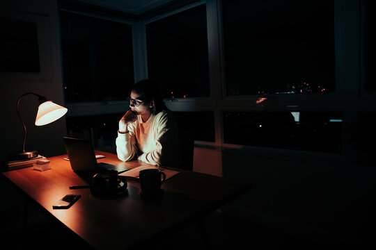 Caucasian Female Student Tired Leaning On Elbow Reading Emails Working Late At Night 