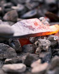 Blacksmith heating a knife in coal