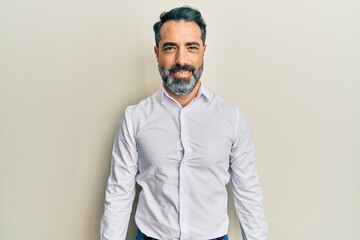 Middle age man with beard and grey hair wearing casual white shirt with a happy and cool smile on face. lucky person.