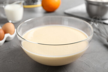 Glass bowl with batter on grey table, closeup