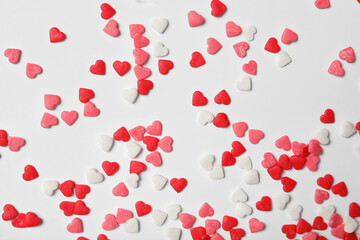 Bright heart shaped sprinkles on white background, flat lay