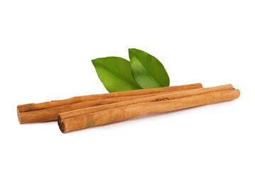 Aromatic dry cinnamon sticks and green leaves on white background