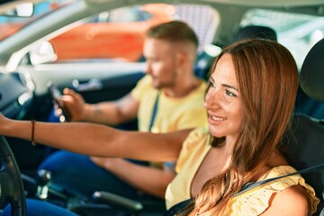 Young couple smiling happy driving car and using gps navigator smartphone.