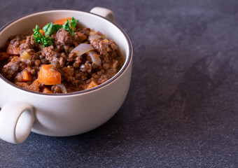 minced meat dish with lentils and vegetables in a soup cup with copy space